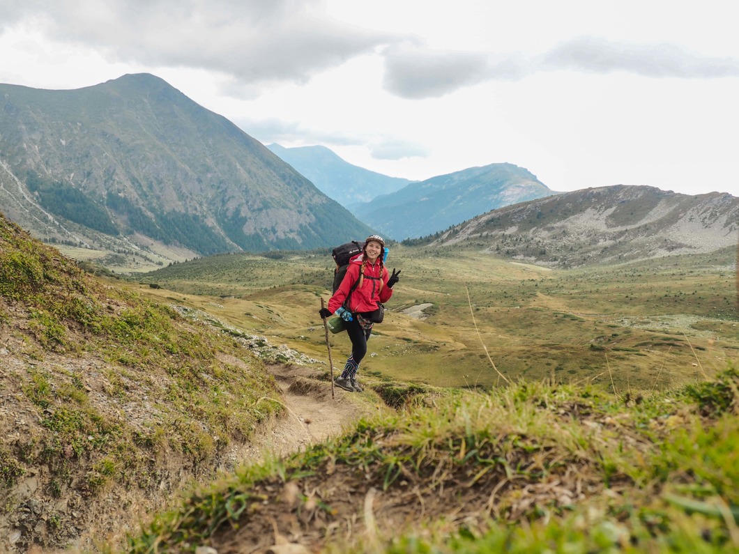 solo female hiker in front of mountains