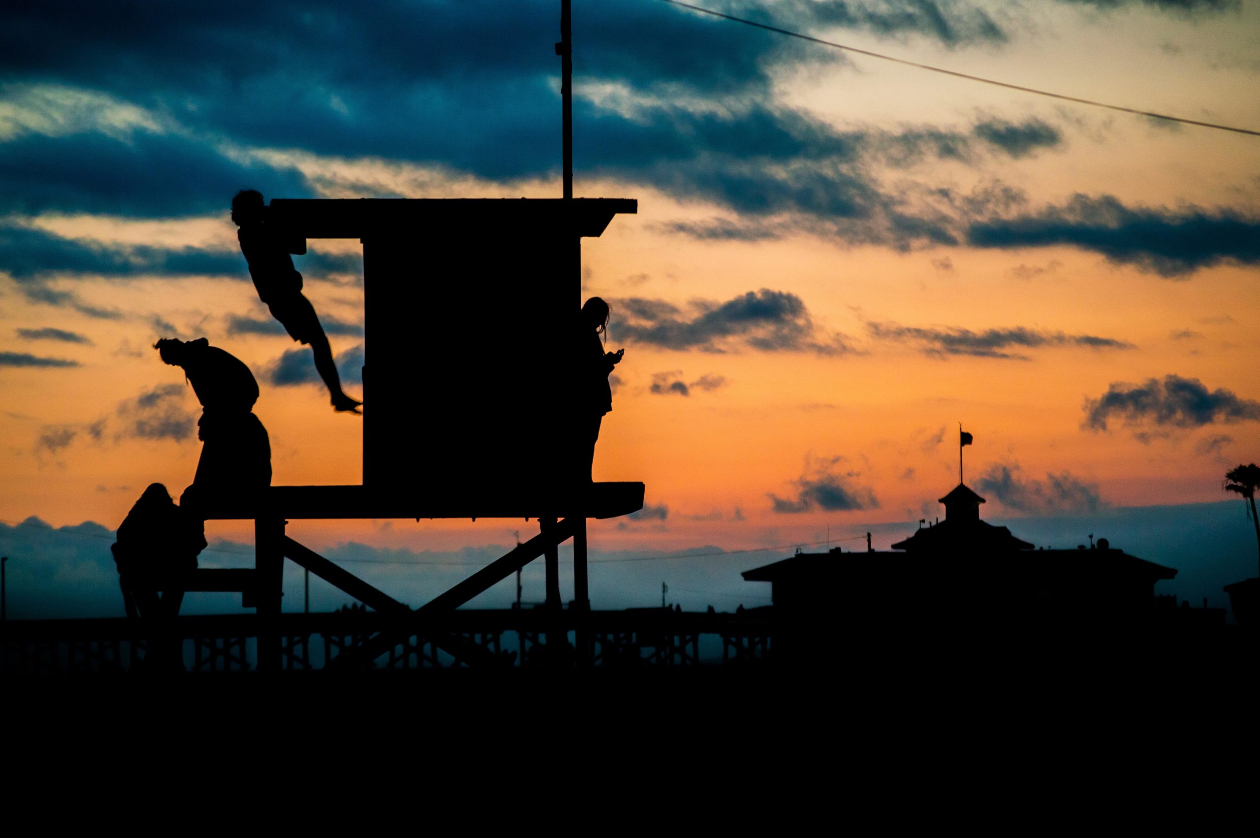 people working out on a lifeguard stand at sunset