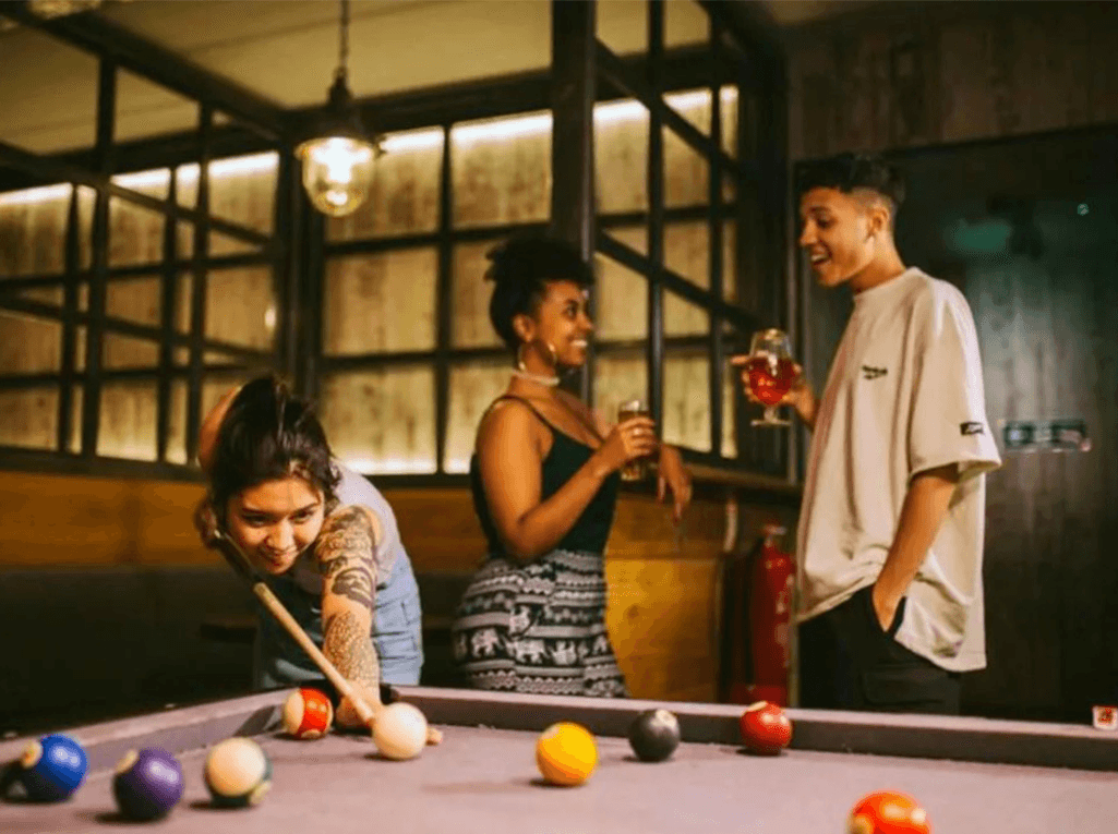People staying at a hostel playing pool